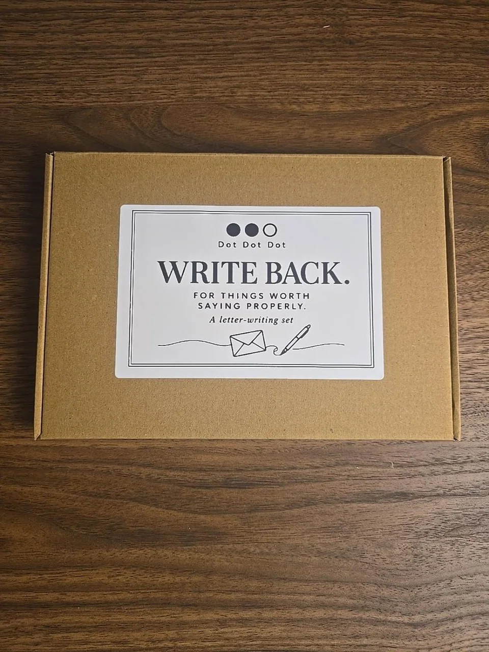 Closed kraft Write Back gift box with its Dot Dot Dot illustrated label